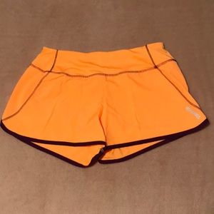 NWOT Reebok athletic dolphin hem shorts with built in briefs. Yellow-orange. XS.